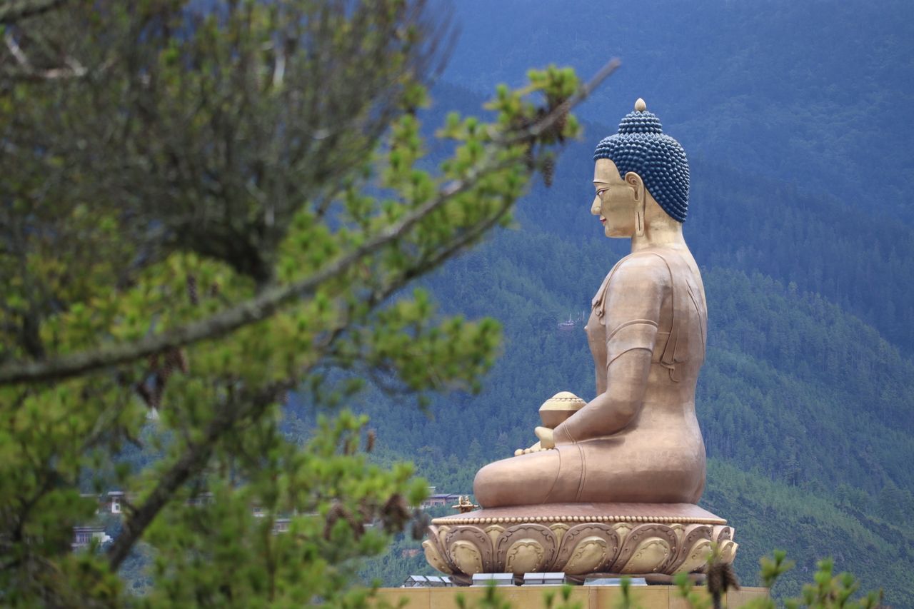 About A majestic golden Buddha statue in Thimphu, Bhutan with scenic mountain backdrop.