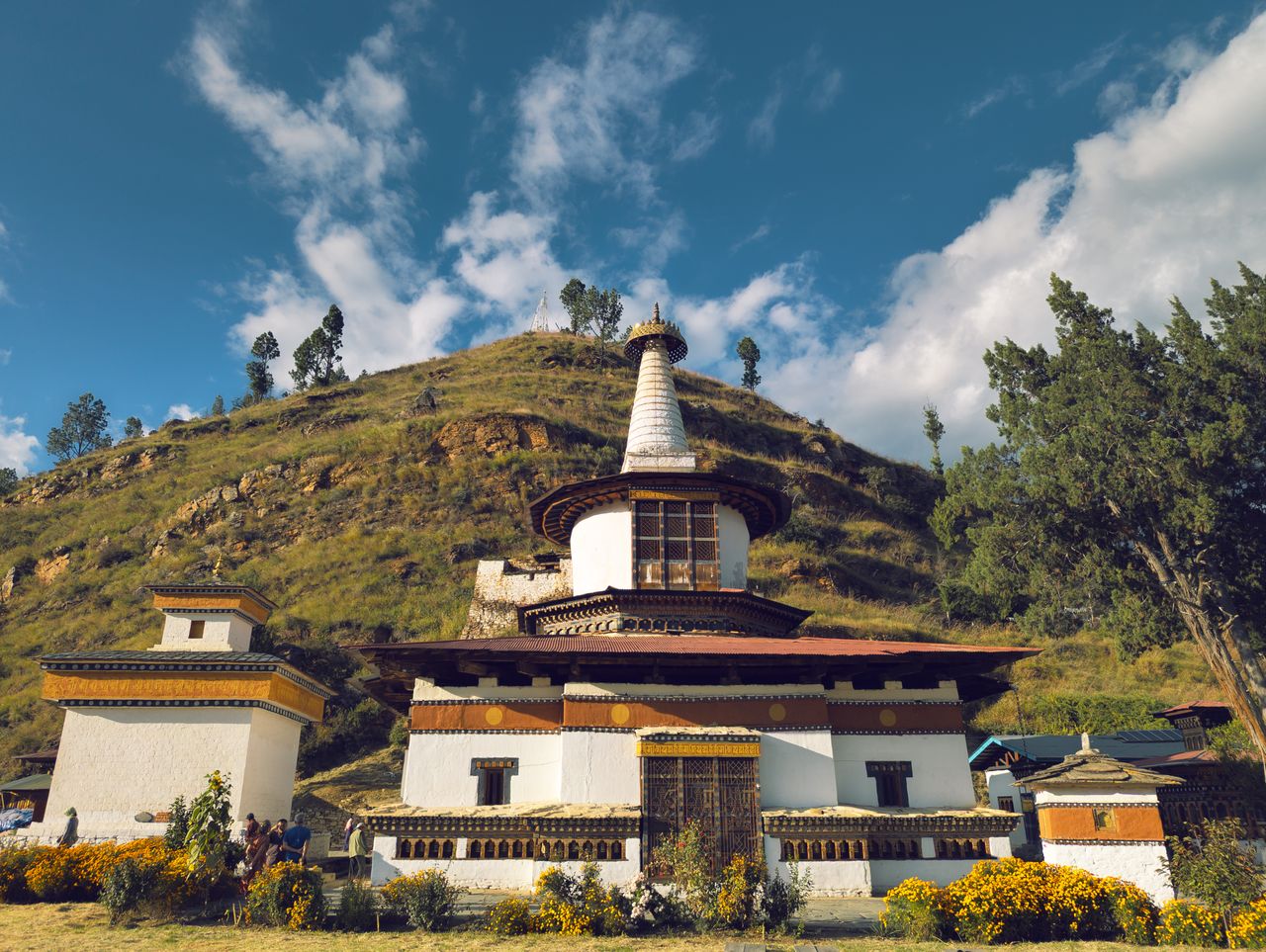 Crafting Captivating Headlines: Your awesome post title goes here Captivating view of a traditional Bhutanese stupa under a clear blue sky in a hilly landscape.