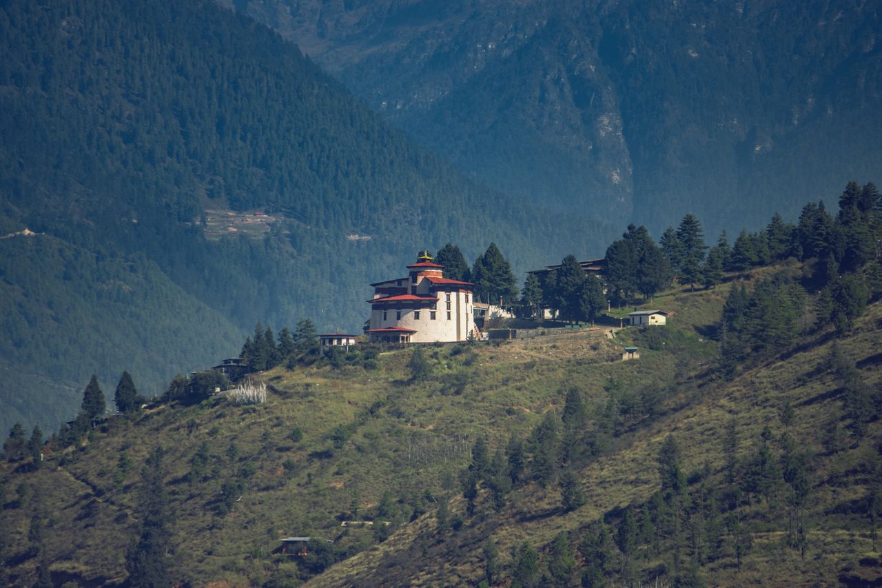 A distant view of Paro Taktsang Monastery nestled in the lush mountains of Bhutan.